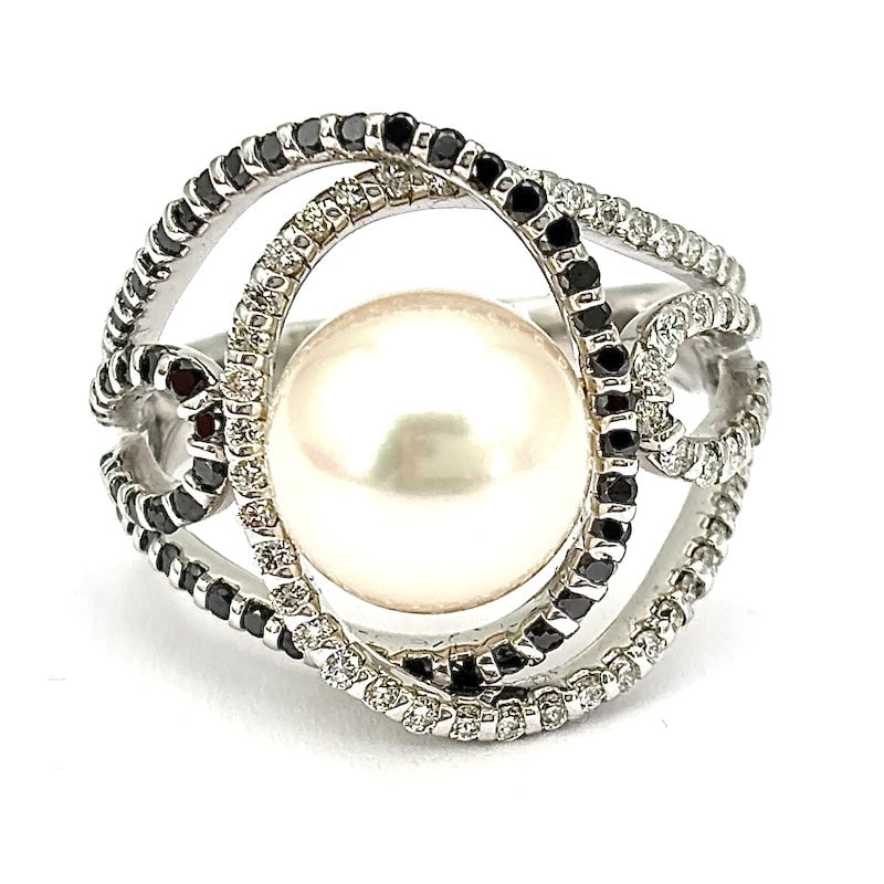 Akoya pearl ring, white gold and black and white diamonds; 8.78 gr.: Fabulous ring with a soft and curvy design in 18 kt white gold with large central Akoya pearl, and soft embrace of black and white diamonds. A super chic black and white! Our company's certification i
