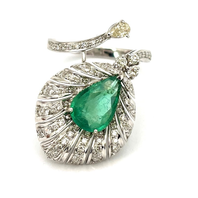 Emerald and diamond feather ring, white gold; 8.93 gr.: An iconic ultra glamorous ring! Contrarie masterpiece feather ring in 18 kt white gold with beautiful drop-cut emerald and a triumph of brilliants. Concluding 12-point champagne-colored teardrop diamo