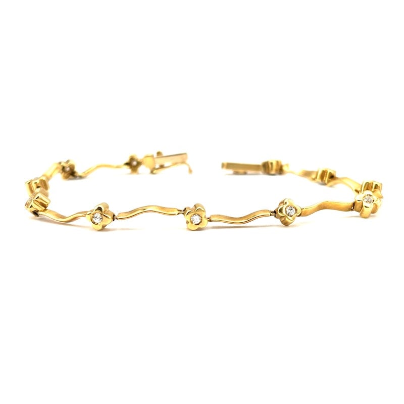 Yellow gold and cubic zirconia tennis bracelet; 8.67 gr - 17 cm: A delightful vintage style tennis bracelet in 18 kt yellow gold, with a wavy pattern design and typically old money repeated cloverleaf bezels. Graceful, precious, handcrafted and exquisite! Our compa