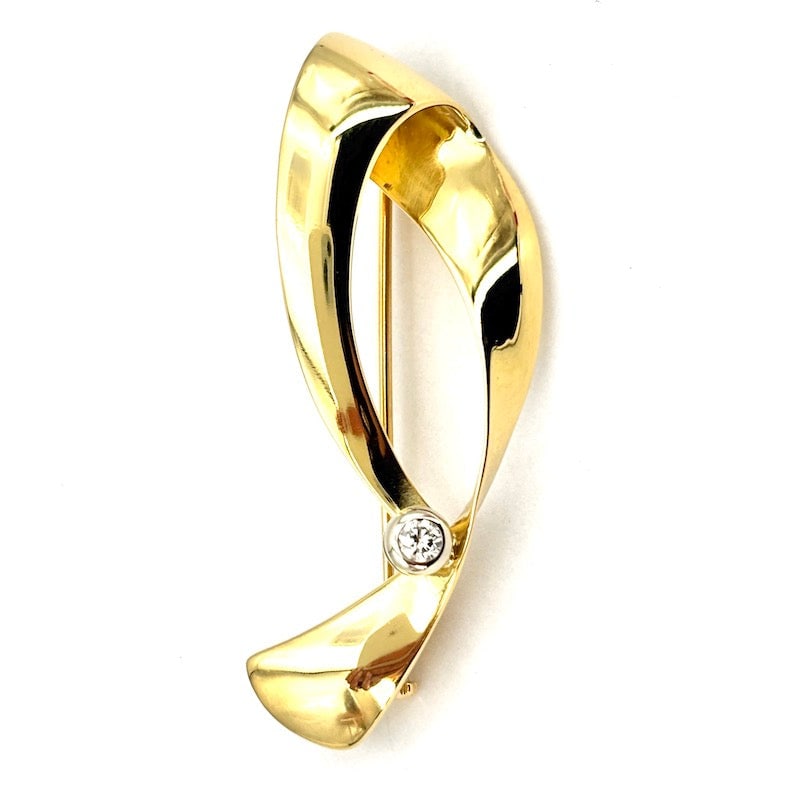 DAMIANI stylized D brooch, yellow gold and brilliant; 7.9 gr.: Masterful and emblematic 1980s vintage, stylized soft D brooch by DAMIANI, egregiously crafted in 18 kt yellow gold and with brilliant solitaire on 18 kt white gold bezel. A bargain pret a porter styl
