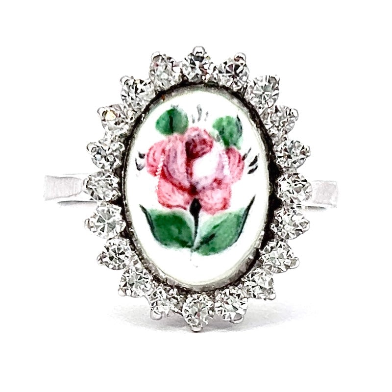 Painted ceramic daisy ring, white gold and cubic zirconia; 2.96 gr.: Exquisite femininity for this artistic and delightful 18 kt white gold ring with adorable central painted ceramic oval and perimeter cubic zirconia. A must-have gem! Our company's certification is ava