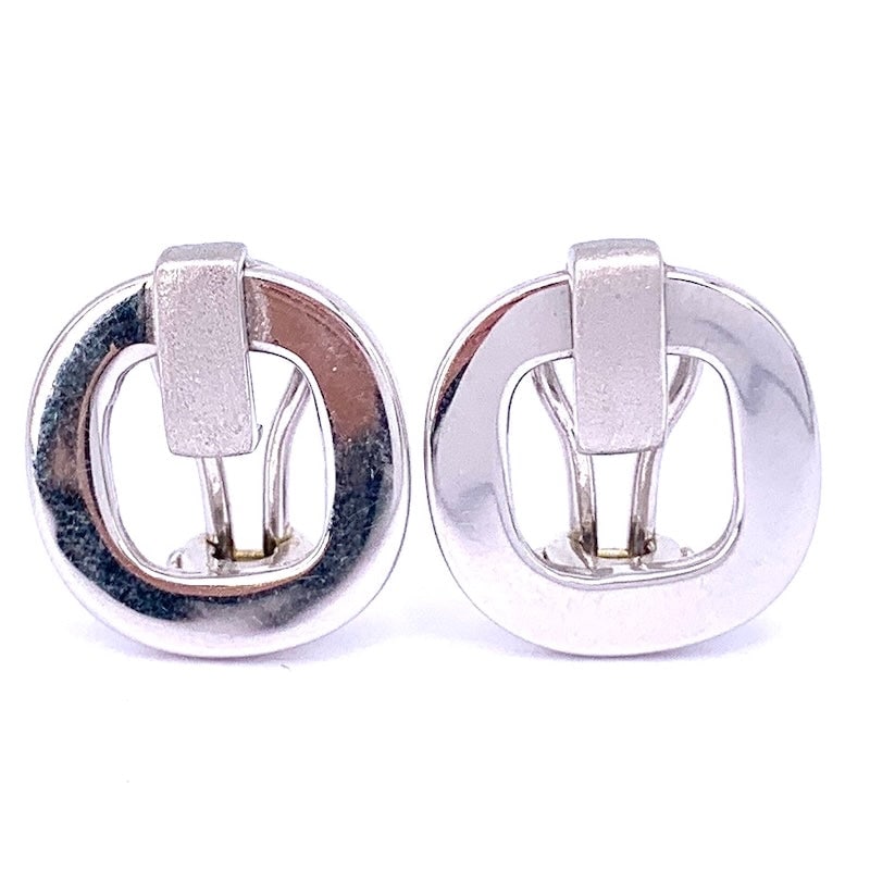 White gold designer lobe earrings; 4.92 gr.: These white gold designer lobe earrings combine modernity and elegance with their polished finish and bold geometric lines. The secure pin-clip clasp ensures comfort and ease of wear. Perfect for thos