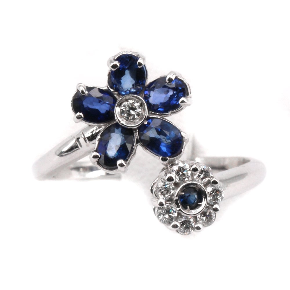 Contrarie double flower ring sapphires, diamonds and gold ; 3.35 gr.: Gorgeous, wrapping and colorful! Contrarie double flower ring in white gold, sapphires and rhinestones. Classic and feminine freshness. Our company's certification is available for free, upon request.