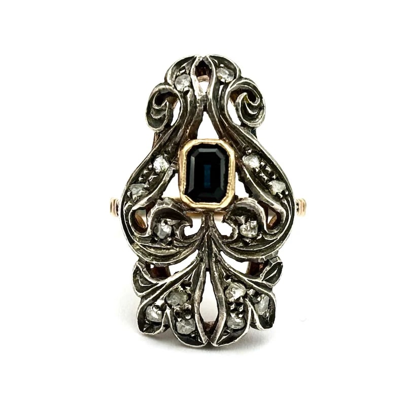 Romantic 18K Yellow Gold & Silver Marquise Style Ring with a 0.20-0.30ct Sapphire and Diamonds,6.87g: Romantic vintage ring in 18K yellow gold and silver, designed in an elongated floral “margherita” silhouette with soft, flowing antique-style lines. The central emerald-cut sapphire is framed