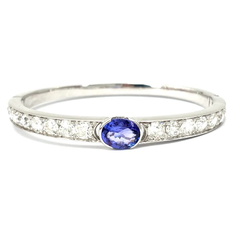 Striking high-end 18K White Gold Bangle Bracelet with 2.49ct Tanzanite and 5.46ct Diamonds, 23.65g: Striking high-end 18K white gold rigid bangle bracelet featuring a luminous oval tanzanite as the central focal point, surrounded by antique-cut brilliant diamonds that create a refined interplay of l
