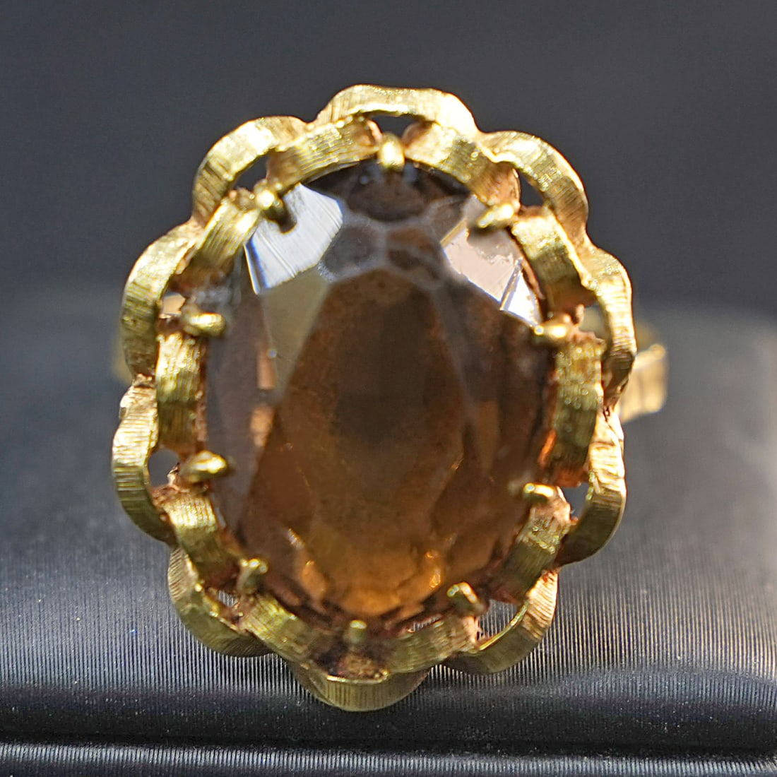 A sophisticated 18K Yellow Gold Ring with Large Smoky Oval Citrine, 9.75gr: A sophisticated ring crafted in 18K yellow gold, featuring a single large smoky oval citrine as the centerpiece. Its deep, warm hue adds a sense of mystery and elegance, while the polished gold settin