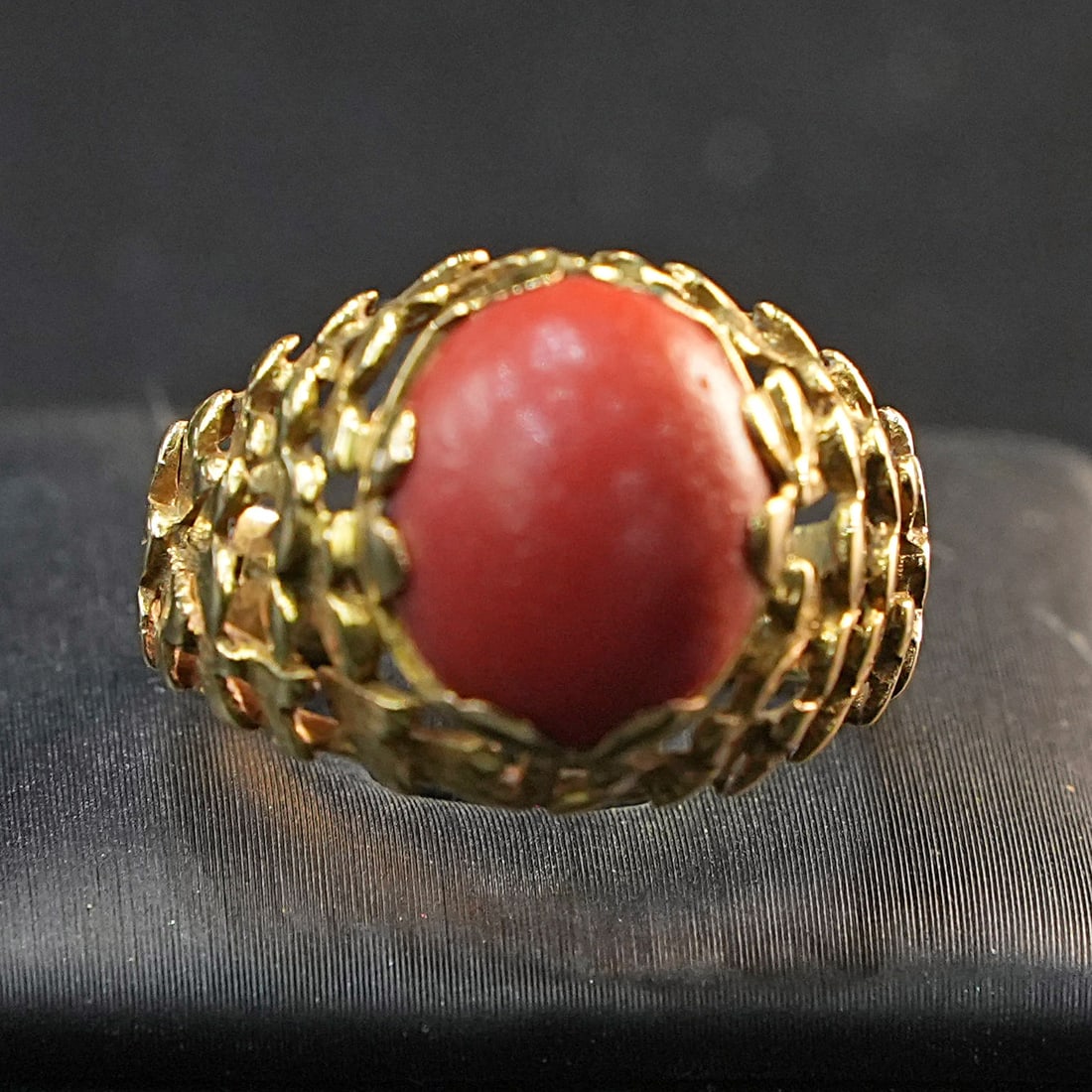 Make yours this Yellow 18K Gold Ring with an Intense Oval Cabochon Coral, 5.82gr: Refined ring crafted in warm 18K yellow gold, featuring a vivid oval cabochon coral that serves as a striking centerpiece. The smooth, polished setting enhances the gem?s rich color and natural allure