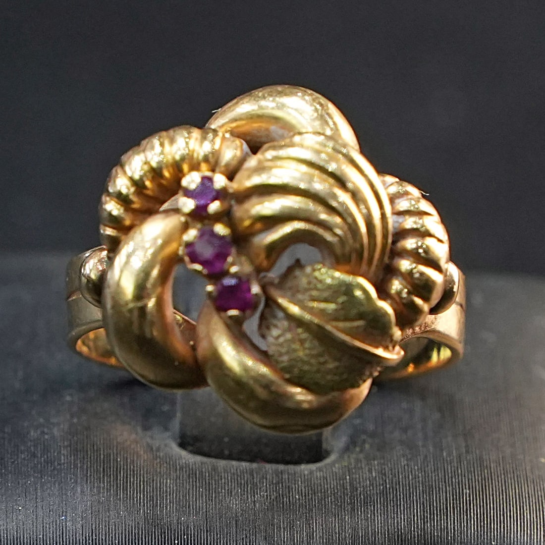 Stylish Yellow 18K Gold Artistic Knot Ring Featuring Three Small Rubies, 6.74gr: Stylish yellow 18K gold ring with a creative knot-inspired design, adorned with three vivid small rubies that enhance its refined, handcrafted charm. The intricate looping motif adds depth and sophist