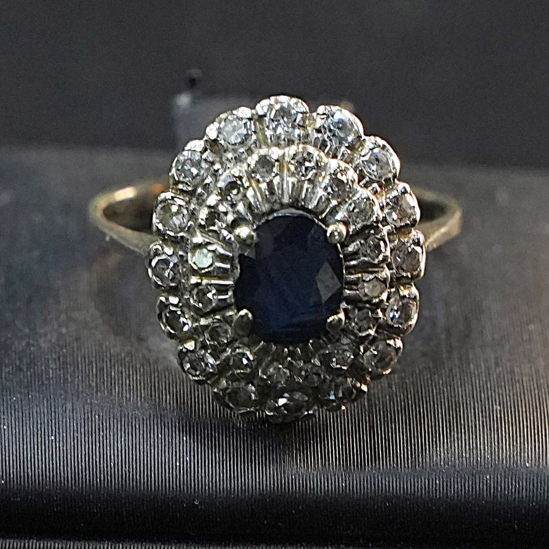 18K White Gold Ring with Central Sapphire Surrounded by Double Halo of Antique-Cut Diamonds, 3.64gr: Timeless 18K white gold ring featuring a vivid central sapphire encircled by two rows of antique-cut diamonds, creating a luxurious and timeless design. The intricate double halo enhances the brillian