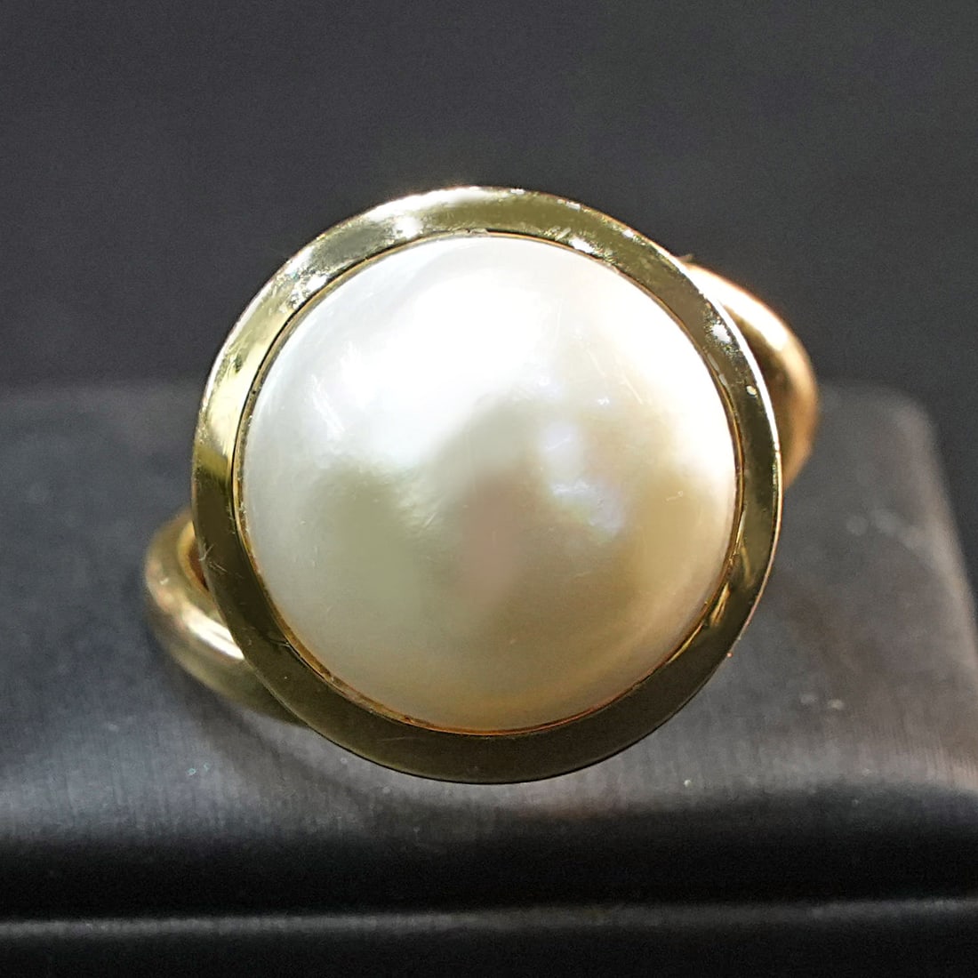 A luminous Mabe Pearl is on this 18kt Yellow Gold Ring giving a Minimalist Elegant Design, 8.39 gr: 18kt yellow gold ring featuring a luminous Mabe pearl that creates a refined and universally appealing minimalist design. The smooth pearl contrasts beautifully with the warm gold band, highlighting a