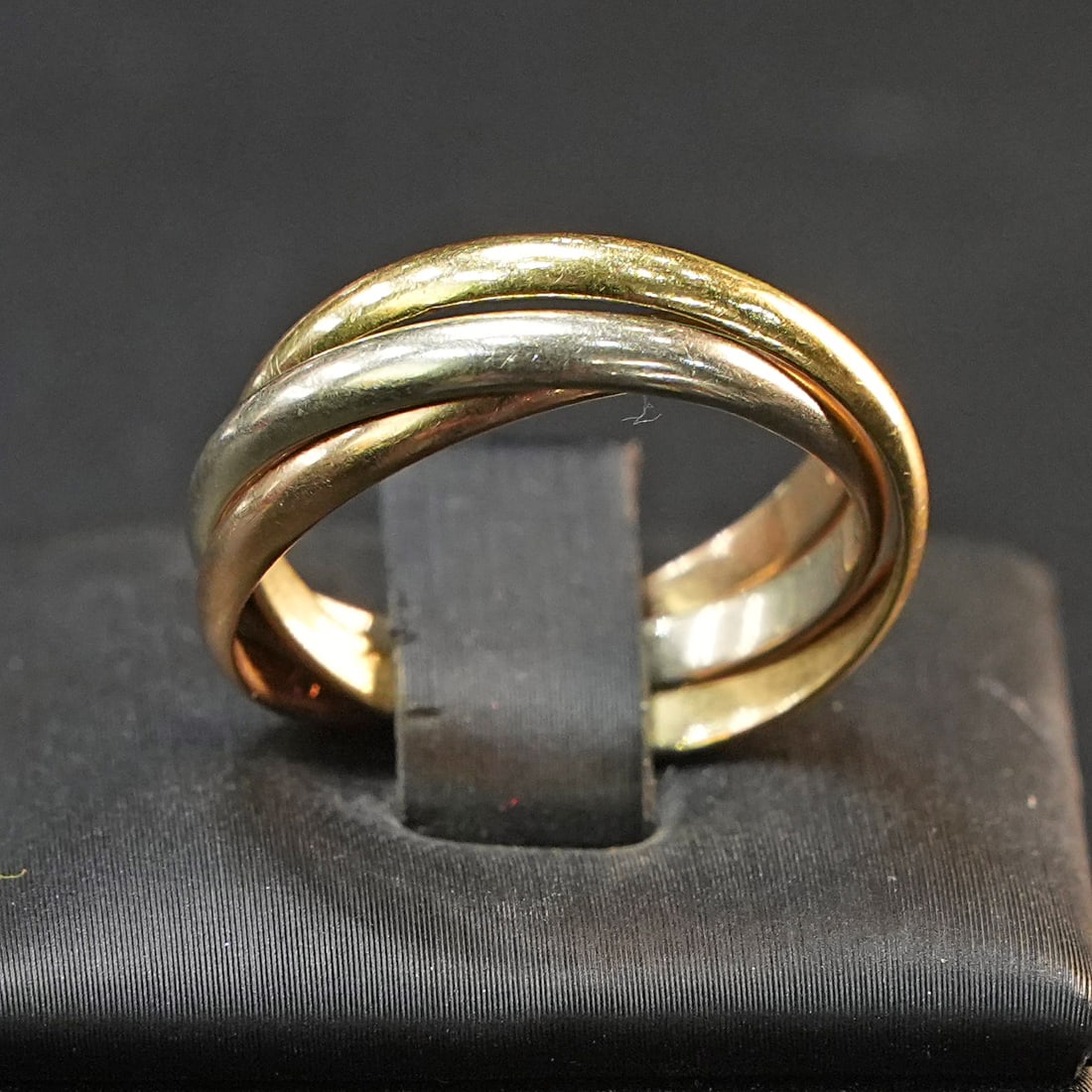 Iconic Cartier Trinity Ring in 18K Yellow, White and Rose Gold with three intertwined Bands, 5.93gr: Iconic Cartier Trinity ring crafted in 18K yellow, white, and rose gold, formed by three gracefully intertwined bands. The flowing design symbolizes harmony and movement, offering a refined yet expres