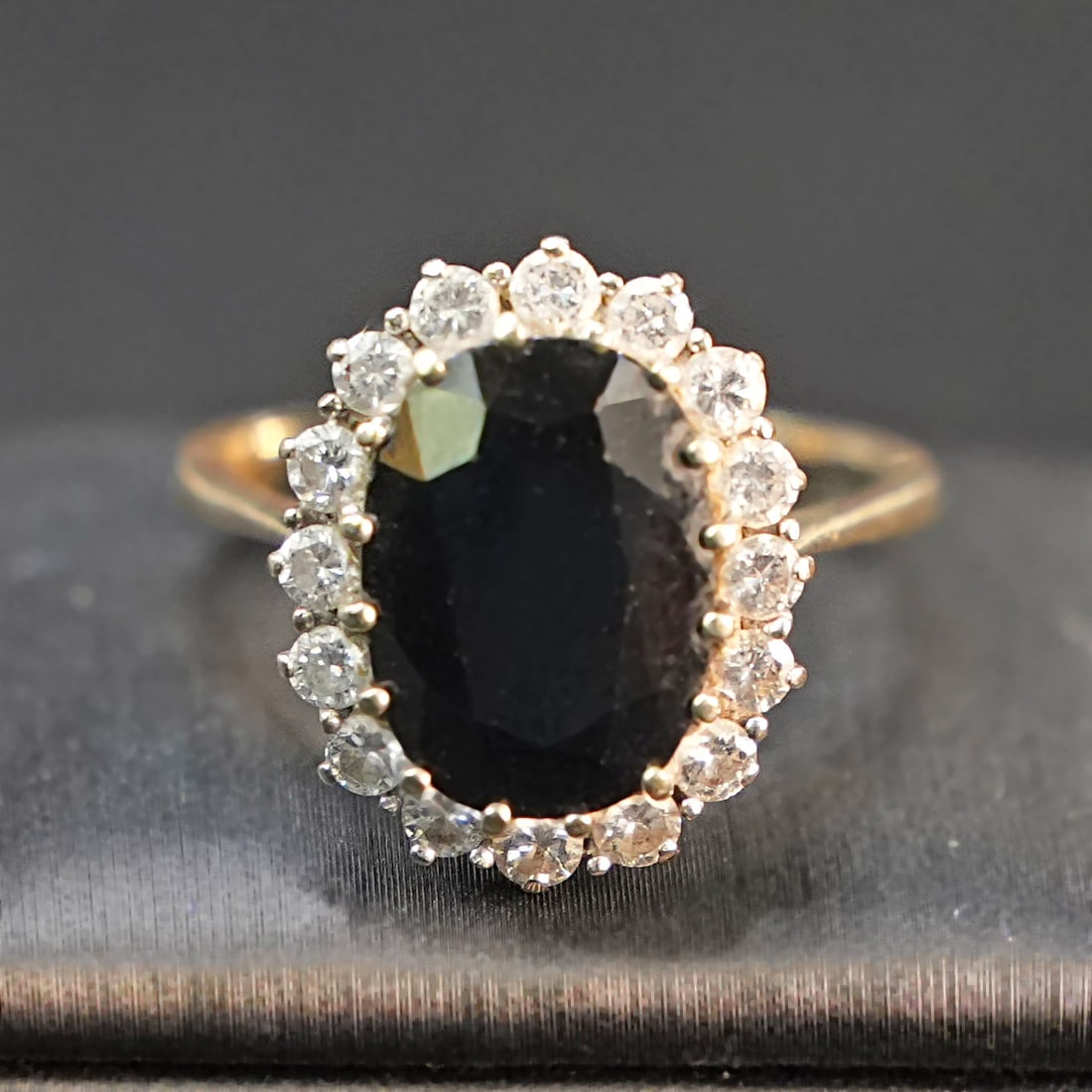 Timeless 18K White Gold Halo Ring with Central Oval Sapphire and 0.8ct Diamond Accents, 5.70gr: Timeless 18K white gold ring featuring a central deep blue oval sapphire, encircled by a halo of brilliant diamonds that enhance its natural radiance. The elegant floral-inspired setting creates a lum