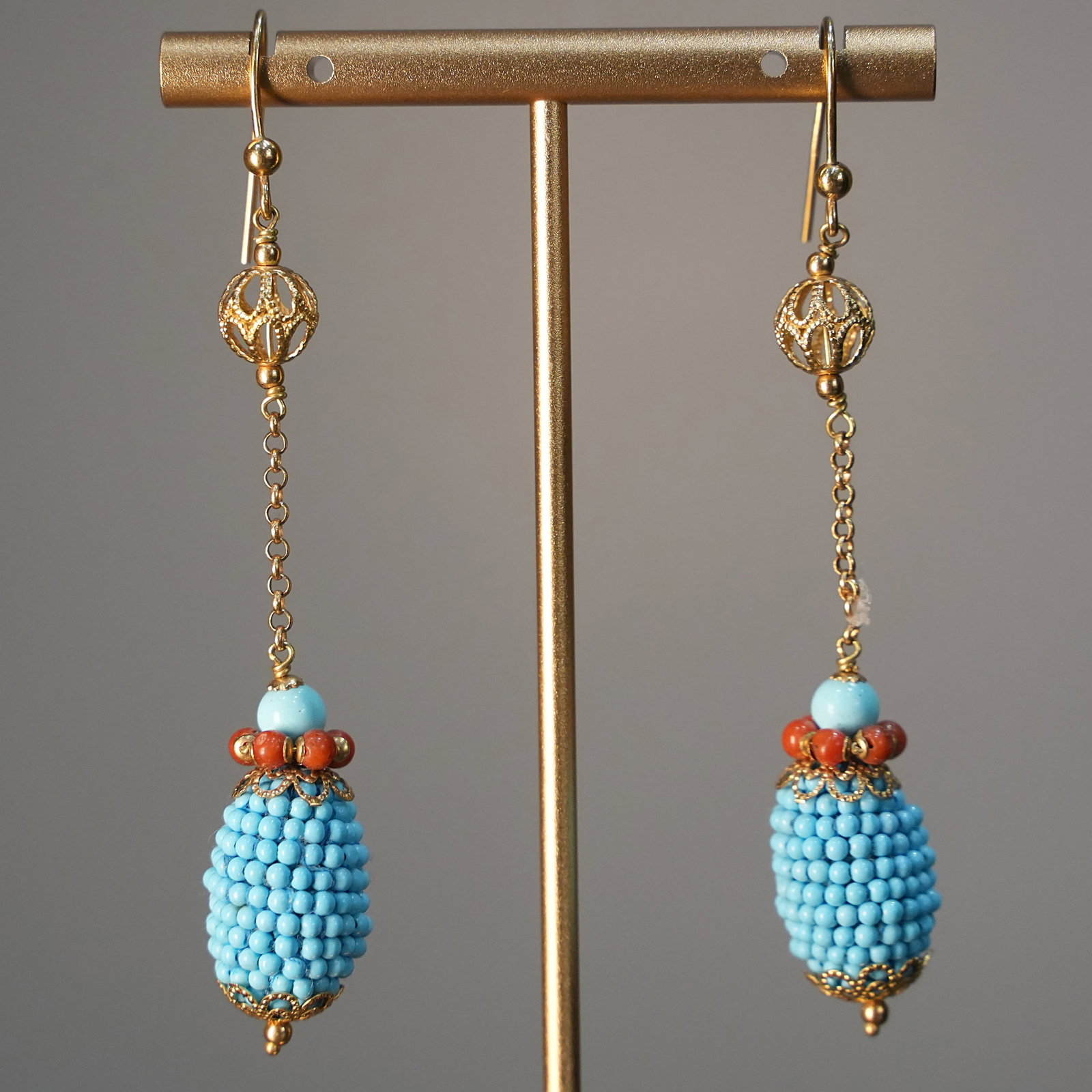 Cluster inspired Design 18K Yellow Gold Drop Earrings with Turquoise Beads and Coral,, 7.68 gr: Delicate and original drop earrings crafted in 18K yellow gold, featuring a playful cluster-inspired motif suspended on fine chains. Adorned with tiny turquoise beads and vibrant red coral accents, th