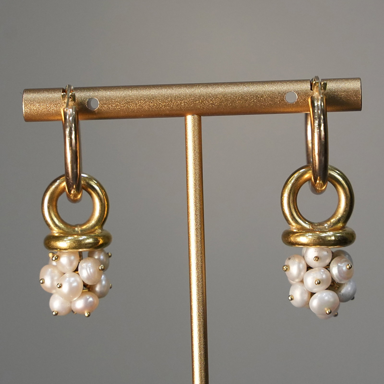 Artisanal Vintage 18K Yellow Gold Hoop Earrings with Cluster of Natural Pearls, 9.89 gr: Vintage yellow gold hoop earrings crafted in 18K, featuring a suspended cluster of tiny natural pearls. The golden hoops support the pearl clusters, creating a dynamic, flowing design with an organic 