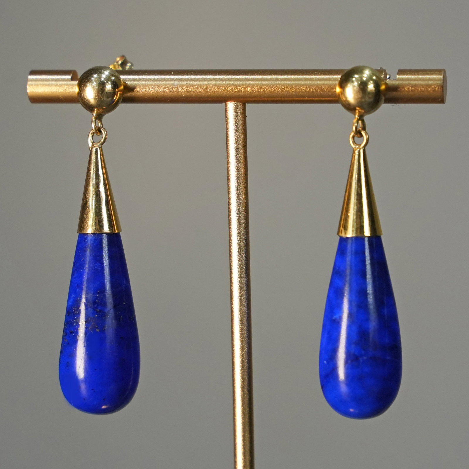 Intense 18K Yellow Gold Drop Earrings with Lapis Lazuli Teardrop Pendants Post Back 14.79gr: Intense drop earrings crafted in 18K yellow gold, designed with post and butterfly backs and finished with teardrop-shaped lapis lazuli pendants. One lapis lazuli shows visible wear and age-related da