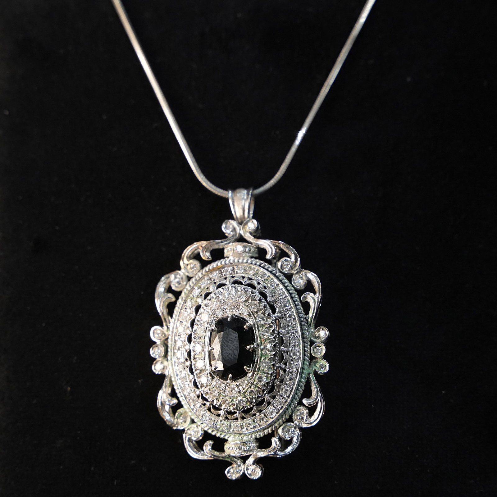 Antique Style 18K White Gold Pendant/Brooch with 79 Diamonds and Australian 2ct Sapphire 14.18gr: A sumptuous antique-style pendant/ brooch crafted in 18K white gold, conceived as a medallion with refined openwork executed with high-precision craftsmanship. The intricate pierced structure creates 