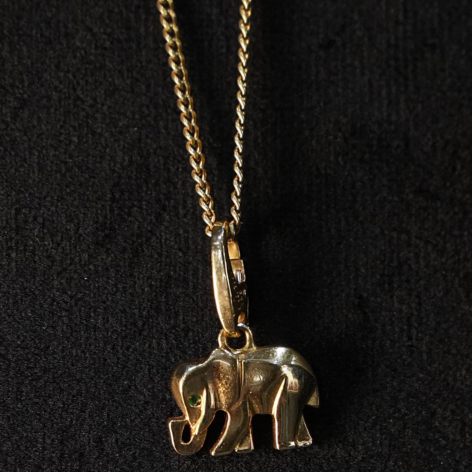 Iconic and Symbolic Cartier Signature Elephant Pendant in 18kt Yellow Gold with Emerald Eye, 3.21gr: Iconic and symbolic Cartier Signature elephant pendant crafted in 18kt yellow gold, featuring a tiny emerald set in the elephant?s eye and a secure lobster clasp, complete with original Cartier certif