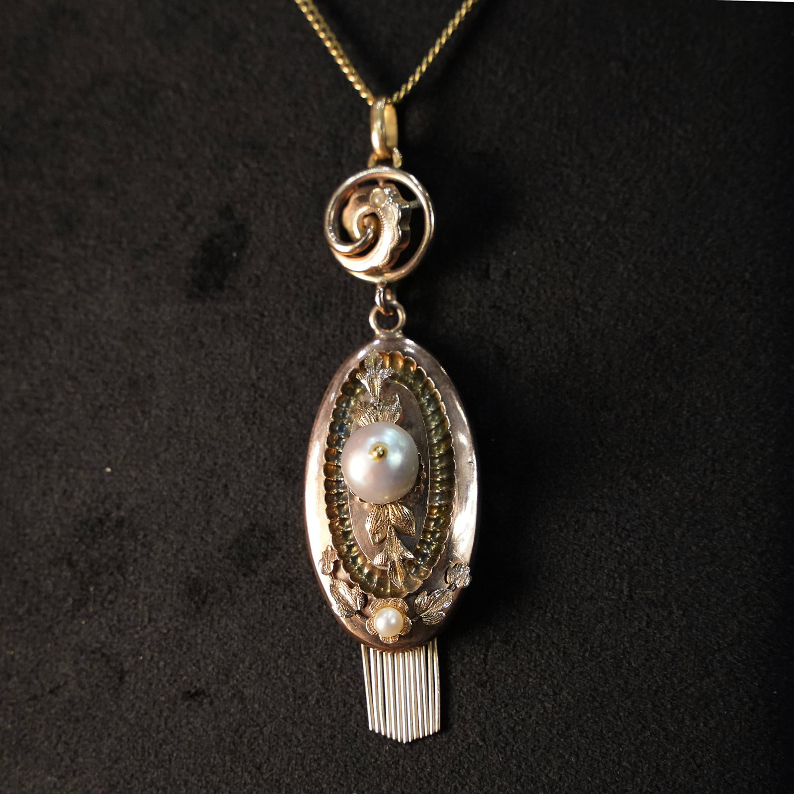 Antique 14kt Rose Gold Oval Pendant with Central and Base Pearls and Decorative Fringe, 6.18gr: Antique 14kt rose gold oval pendant featuring a hollowed central section topped by a circular scrollwork element, adorned with applied floral and leafy motifs, and highlighted by a prominent central p