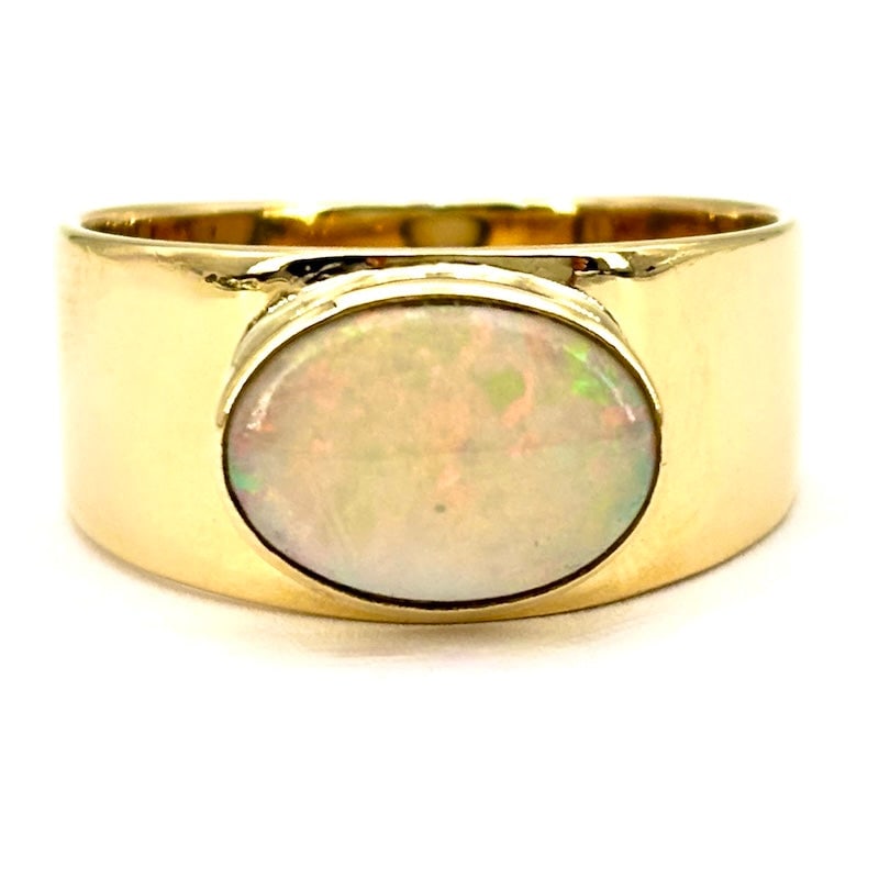 Opal and yellow gold band ring; 7.2 gr.: Fabulous and essential unisex band ring with beautiful oval cabochon opal mounted horizontally on 18kt yellow gold. A smooth, opalescent and most precious jewel offered at a price to die for! Our