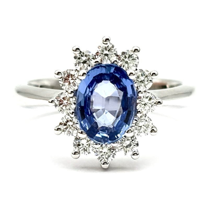 Daisy ring sapphire and diamonds ; 6.17 gr: A timeless, must-have classic in a blue variant of the highest jewelry! White gold daisy ring with superlative central oval-cut sapphire framed by fabulous brilliants. The must-have royal ring! Our