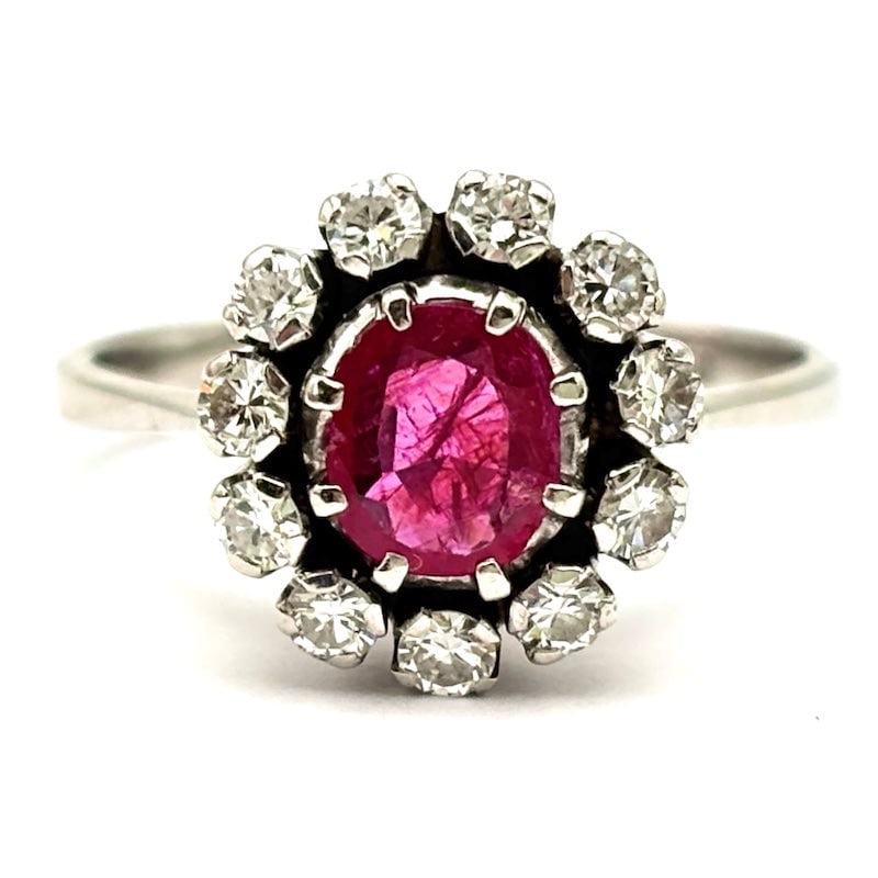 Raised daisy ring of ruby, diamonds and gold; 4.42 gr.: Intense and regal raised daisy model ring in 18 kt white gold, with ruby centerpiece for 0.60/0.70 ct and luminescent diamond perimeter. A high jewelry classic reconditioned to new and priced to die f