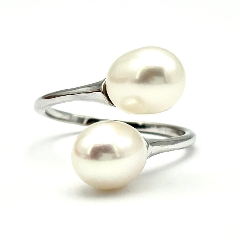 Pearl and white gold contrarie ring; 3.79 gr.: Sophisticated 18 kt white gold contrarie ring combining two slightly pearls in an adorable "toi et moi" effect. Simple and classy. Our company's certification is available for free, upon request. If y