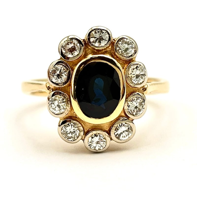 Vintage sapphire and diamond daisy ring; 4.84 gr.: Delightful vintage demode daisy ring proposal in yellow gold with central sapphire and perimeter diamonds, mounted on yellow onion bezels. A great classic that marries retro flair for top materiality 