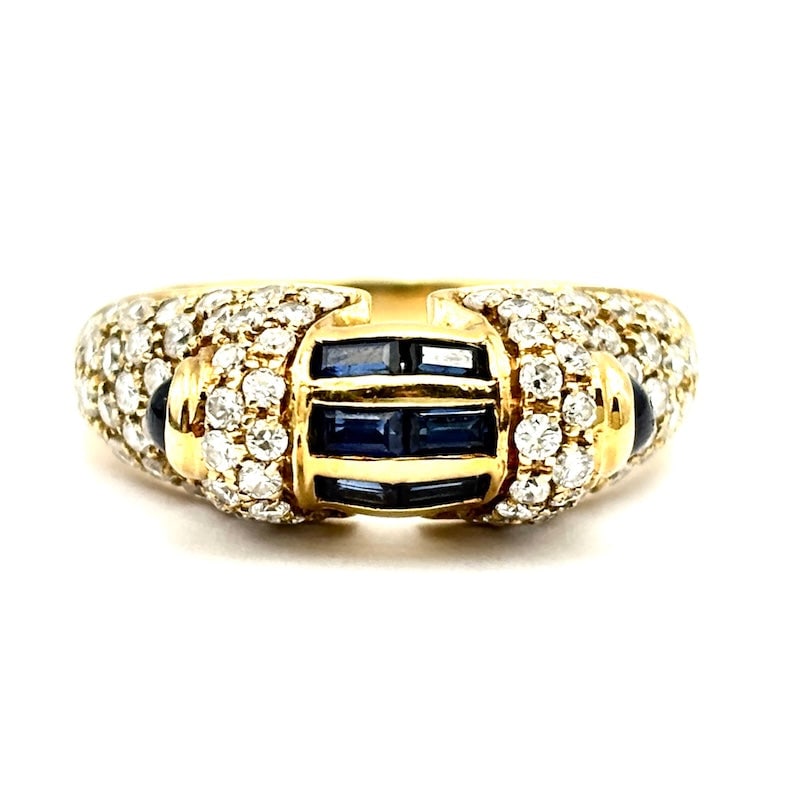 Band bridge ring baguettes of sapphires, diamonds and yellow gold; 6.74 gr.: Very original and charming uniqueness for this 1980s band bridge ring in 18 kt yellow gold with blue baguettes and cabochon sapphires and brilliants. Unique one-of-a-kind piece, garish and very afford