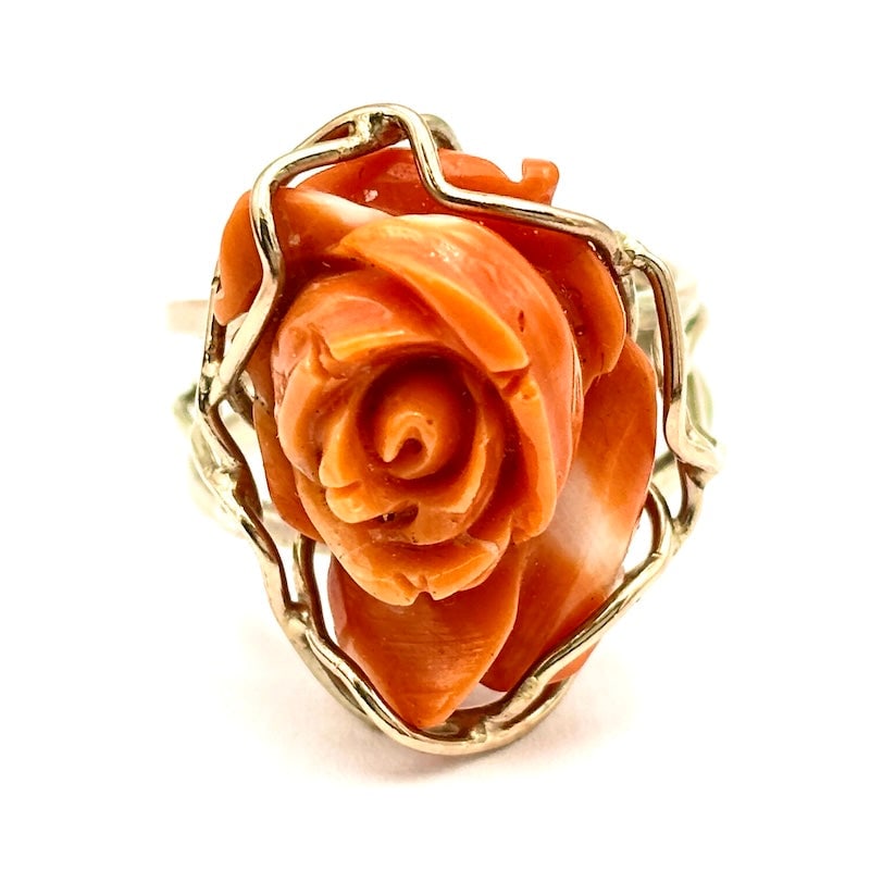 Pink ring of momo coral and yellow gold; 7.48 gr.: Vintage yellow gold ring with rose carved in uneven salmon-colored momo coral, a symbol of elegance and femininity. The setting features branches that enhance the handcrafted design and beauty of one 