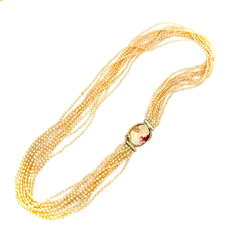 Long necklace 10 strands microbeads, vintage cameo and gold - 70 cm; 93.85 gr.: Scenic and very important 10-strand long torchon necklace of irregular river pearls, with vintage cameo mounted on 18 kt yellow gold. An enveloping cascade of vintage whiteness and character! Our comp