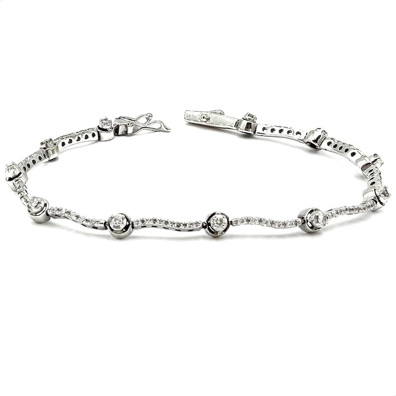 Solitaire and diamond wave tennis bracelet, white gold - 0.50-0.60 ct; 7.85 gr - 17 cm: Exquisite and charming reconditioned used tennis bracelet in 18 kt white gold, mounting 0.50-0.60 ct total solitaires, alternating with waves of brilliants. A romantic and unfailing alternative to the