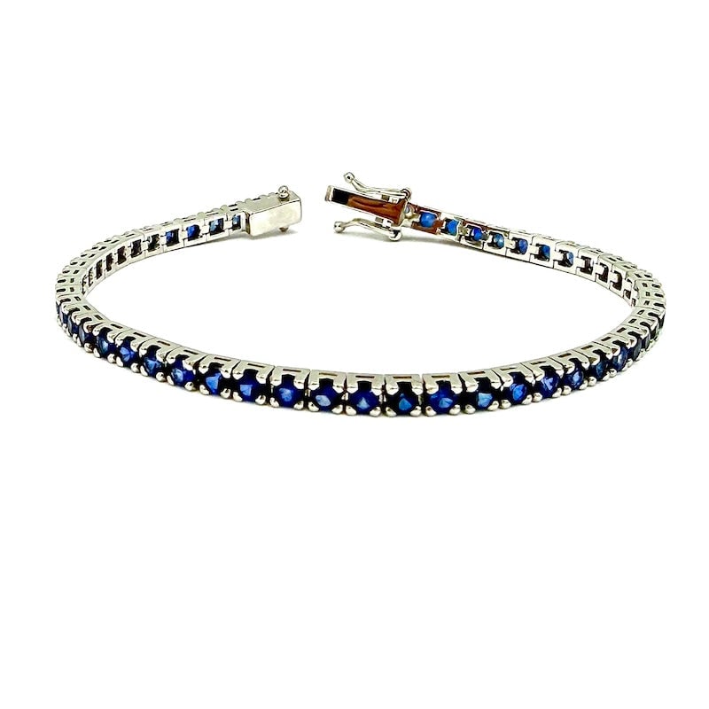 Blue sapphires and white gold tennis bracelet - 6.01 ct; 11.85 gr.: Intense tennis bracelet with over 6 ct blue sapphires on 18 kt white gold turned mount. Double figure-of-eight safety clasp. A deep and special variation of the ultimate eternity strand! Our company's