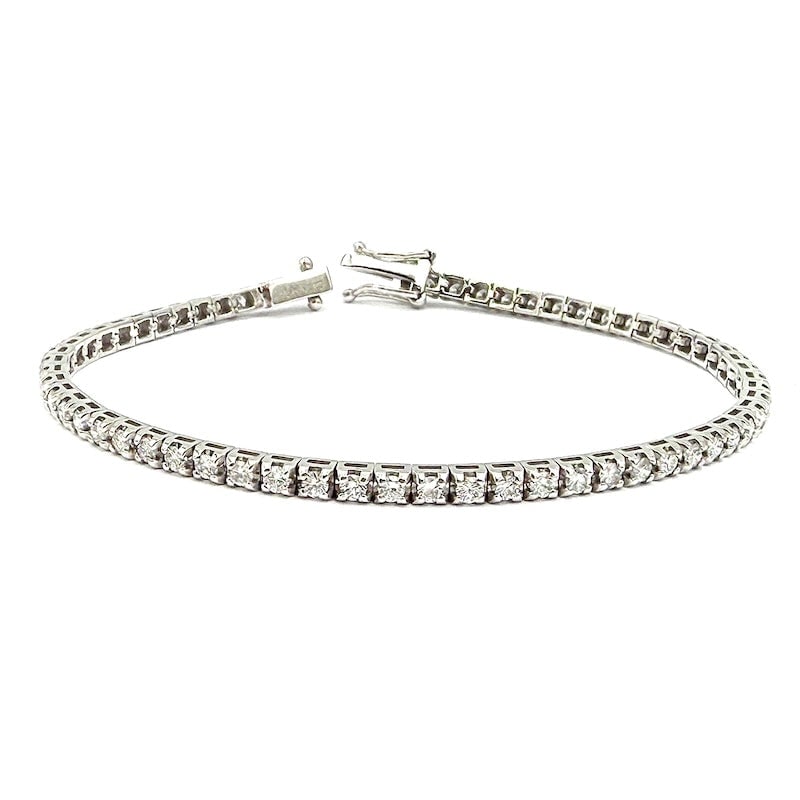White gold and diamond tennis bracelet - 2.88 ct; 9.44 gr - 18 cm: Classic, fabulous, 18 kt white gold tennis bracelet, mounting 2.88 ct total of gorgeous full-round brilliants, set in 4 square griffes on turned mount. The ultimate strand of eternity at a second-hand