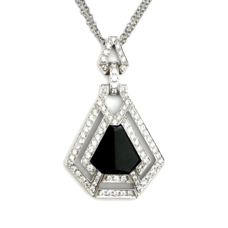 Deco-style pendant necklace with onyx, diamonds and white gold; 12.62 gr.: A very fine black-and-white onyx maxi pendant jewelry, surrounded by geometric patterns of deco-inspired diamonds. 18 kt white gold the admirable setting and double chain, for an exclusive, black-and-