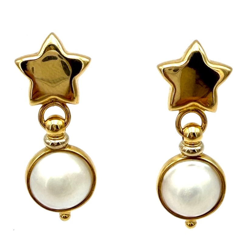 Dangling earrings mabe pearls and stars, yellow gold - 3.5 cm; 7.5 gr.: These eye-catching drop earrings in 18K yellow gold showcase lustrous white mabe pearls paired with bold star-shaped accents, offering a stylish yet graceful look with a youthful, radiant charm. Weigh