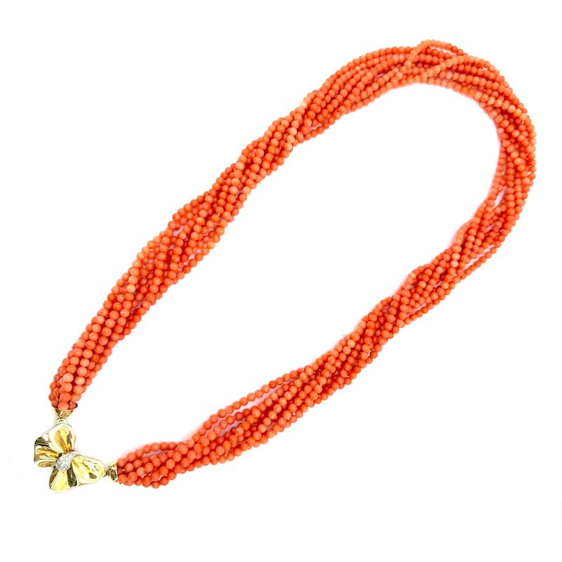 Multi-strand long 8-strand coral and gold bow necklace - 174 gr; 74 cm: Choreographic long multi-strand torchon necklace composed of 8 strands of natural salmon coral, in mini spheres, with important vintage 18 kt yellow gold and diamond bow clasp. A long, feminine, sceni