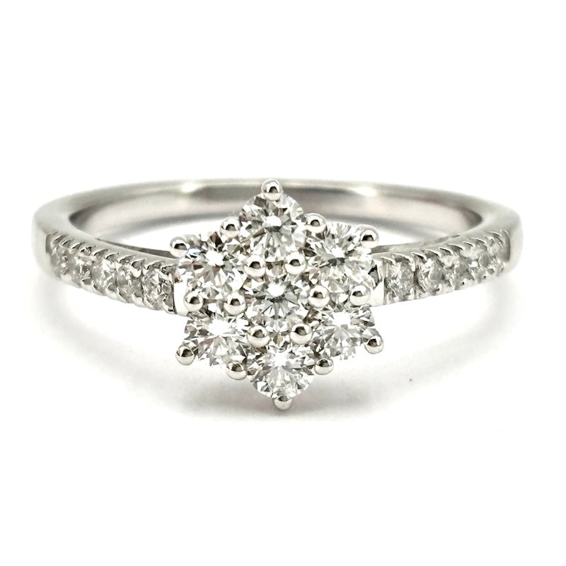 White gold and diamond flower ring; 0.65 ct ; 3.21 gr: A bright, highly prized and eternal diamond flower! Circular daisy ring in 18 kt white gold with 0.65 ct total brilliant-cut diamonds between flower and shank-front diamonds. An eternal and inescapabl