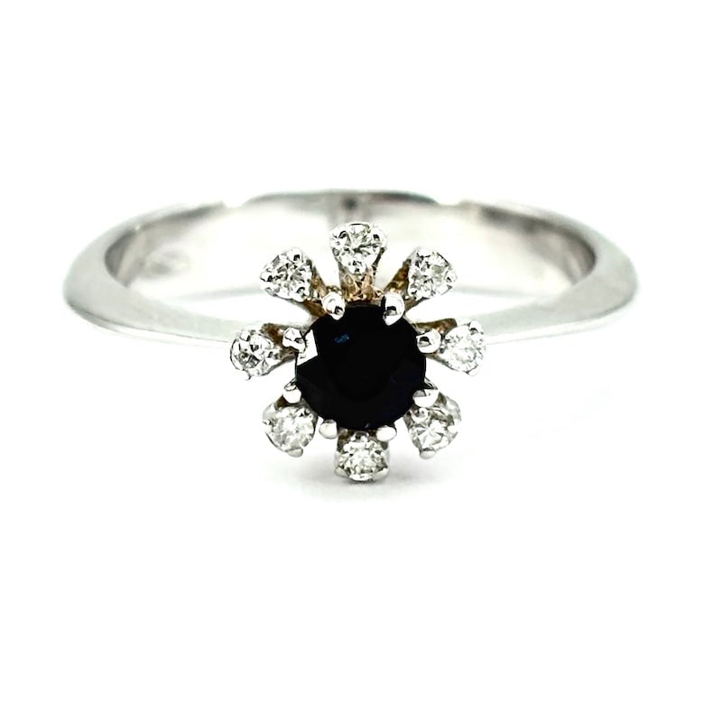 Circular sapphire and brilliants flower ring ; 3.66 gr.: Delightful white gold flower ring with a central round-cut sapphire framed by brilliants. A new, fresh, very accessible variant with a vaguely retro flavor! Our company's certification is available