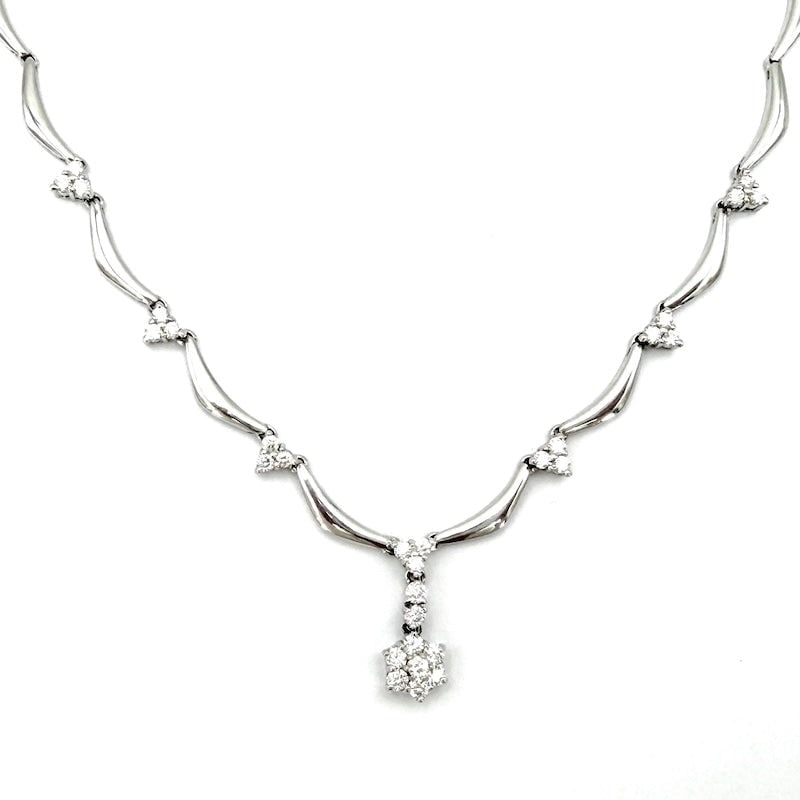 White gold necklace with diamond flower pendant and 7 diamond trilogy; 16.96 gr.: Sophistication, class, elegance, absolute value and a touch of romance! Semi-rigid 18 kt white gold wave necklace with 7 trilogy diamonds and concluding flower pendant. Luminous harmony in one preciou
