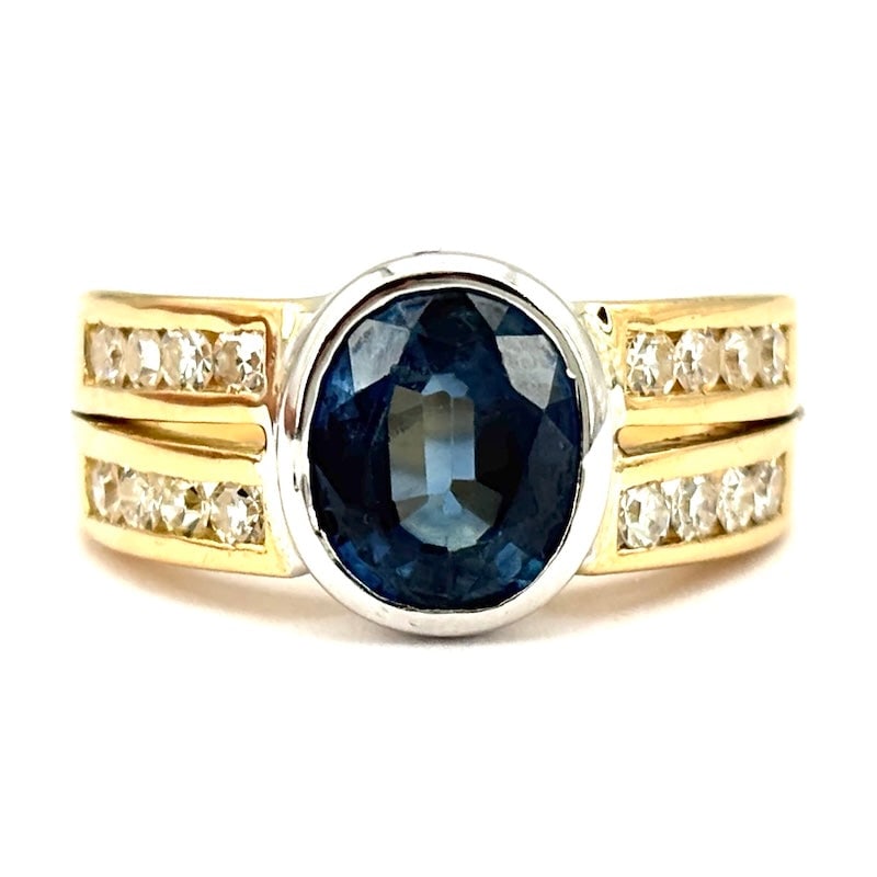 Sapphire, diamond and gold band ring; 6.4 gr.: Gorgeous two-tone 18 kt gold band ring with fabulous oval blue sapphire center and brilliants set on double side tracks. Like new! Incredible value for money! Wow! Our company's certification is avail