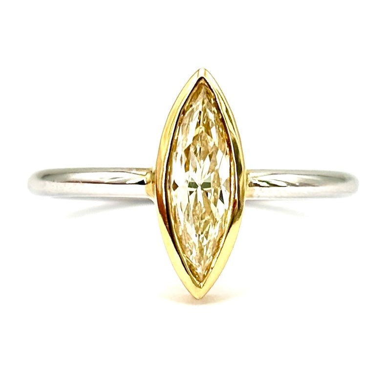 0.79 ct fancy diamond marquise ring, yellow and white gold; 3.04 g: Minimal, fashionable and simply enchanting!!! Essential and stunning 18 kt white gold ring with central marquise-cut fancy light yellow diamond framed smooth and clean in 18 kt yellow gold. Masterpiec