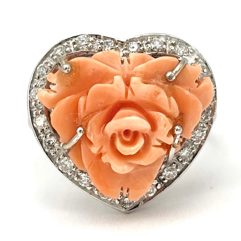 Pink coral, brilliants and white gold heart ring; 9.55 gr.: Sophisticated, artistic and romantic heart ring with starring natural pink coral rose, framed by brilliants, 18 kt white gold setting with brilliants also on full-turn shank. Admirable workmanship and