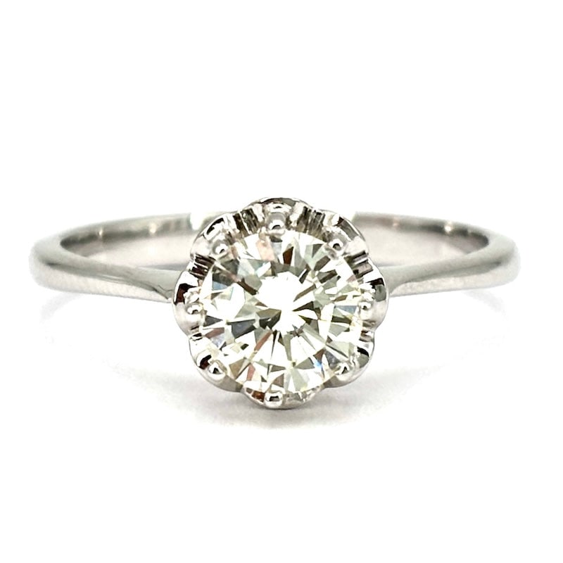 Brilliant solitaire and white gold ring - 0.89 ct; 3.29 gr.: Large bargain solitaire diamond mounted in 8 griffes on retro flower bezel, 18 kt white gold. K color for a warm light with an old-fashioned feel! Our company's certification is available for free, up