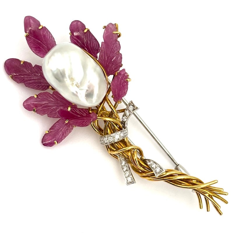 Artistic flower brooch, Australian pearl, ruby leaves, gold and diamonds; 22.92 gr.: Very elegant yellow gold artistic brooch with a floral design, featuring a baroque Australian pearl as the flower centerpiece radiating sophistication and leaf rubies as the corolla adding a touch of 
