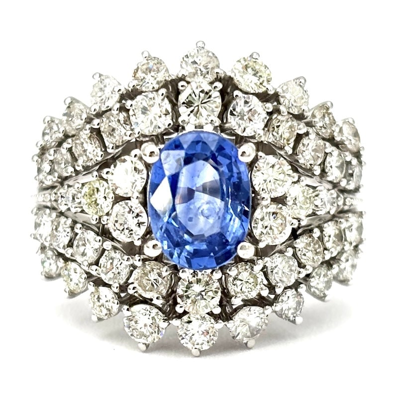 Masterpiece ring sapphire band and triumph of brilliants, white gold; 8.34 gr.: Fabulous 18 kt white gold band ring, embellished with a stunning 1.67-carat blue sapphire and a triumph of brilliants that envelops the setting with endless sparkle. The bold and unique luxury for a s