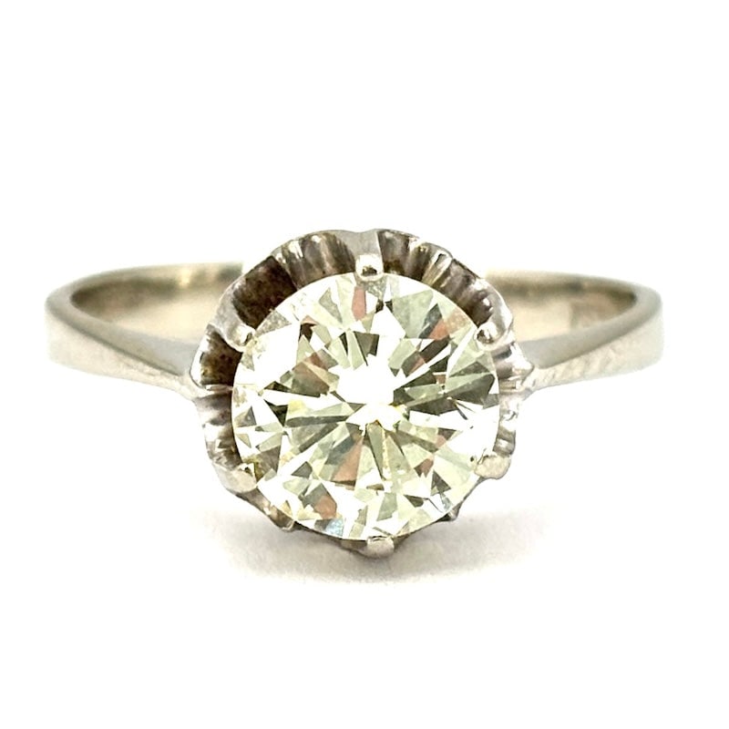 Brilliant solitaire and white gold ring - 1.60 ct; 3.59 gr.: Large bargain solitaire diamond mounted 6 griffes on retro flower bezel, in 18 kt. champagne white gold. M color for a warm light with an old-fashioned feel! Our company's certification is available f
