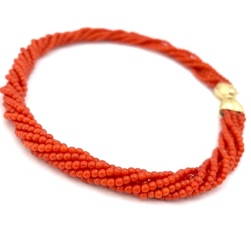 7-strand red coral and gold torchon necklace - 46.16 gr; 44 cm: Beautiful and sophisticated torchon choker necklace composed of 7 strands of natural red coral, in mini spheres, with important 18 kt yellow gold vintage bow clasp. A passionate red multi-strand choke
