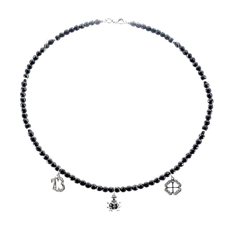 Onyx, diamond and gold strangle necklace, good luck charms; 14.5 gr.: A jewel porte bonheur young and universal! Semi-rigid strangle necklace in faceted onyx boulles, with 18 kt white gold spacers, clasp and charms. The good-luck charms hanging from the necklace are a l
