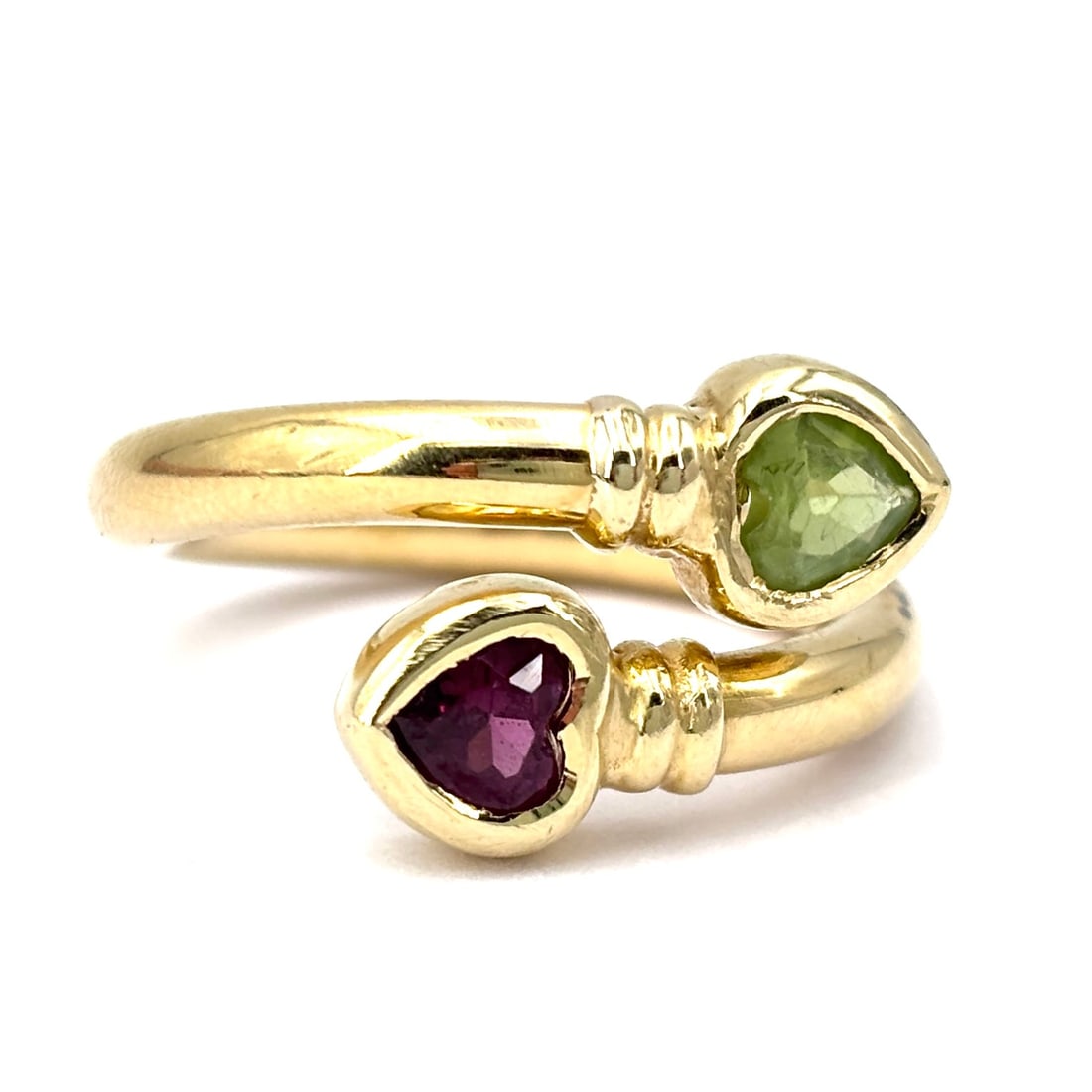 Contrarie ring hearts peridot and garnet, yellow gold; 6.47 gr.: Stunning plain and domed yellow gold double heart contrarie ring. The wrap-around design and heart-cut natural colored gemstones (peridot and garnet) enhance the feminine appeal of this piece of jewel