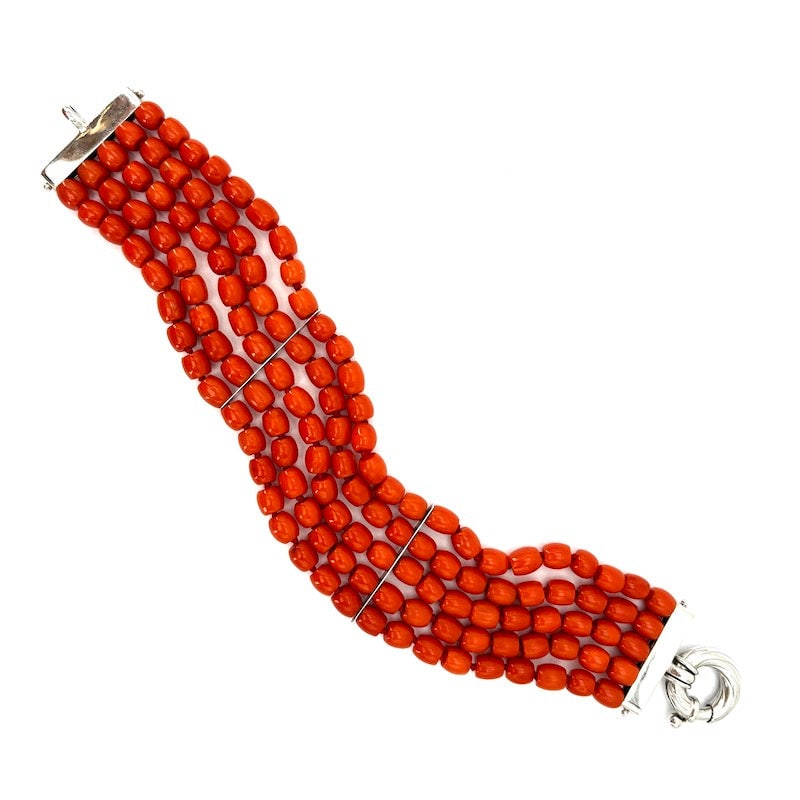 Coral and gold multi-strand barrel bracelet; 18.5 cm - 43.28 gr.: A very passionate wide band, 5-strand bracelet of Mediterranean red coral barrels! Bracelet 18.5 cm long and 2.8 cm high. 18 kt white gold circular maxi lobster clasp and strand spreading bars. An int